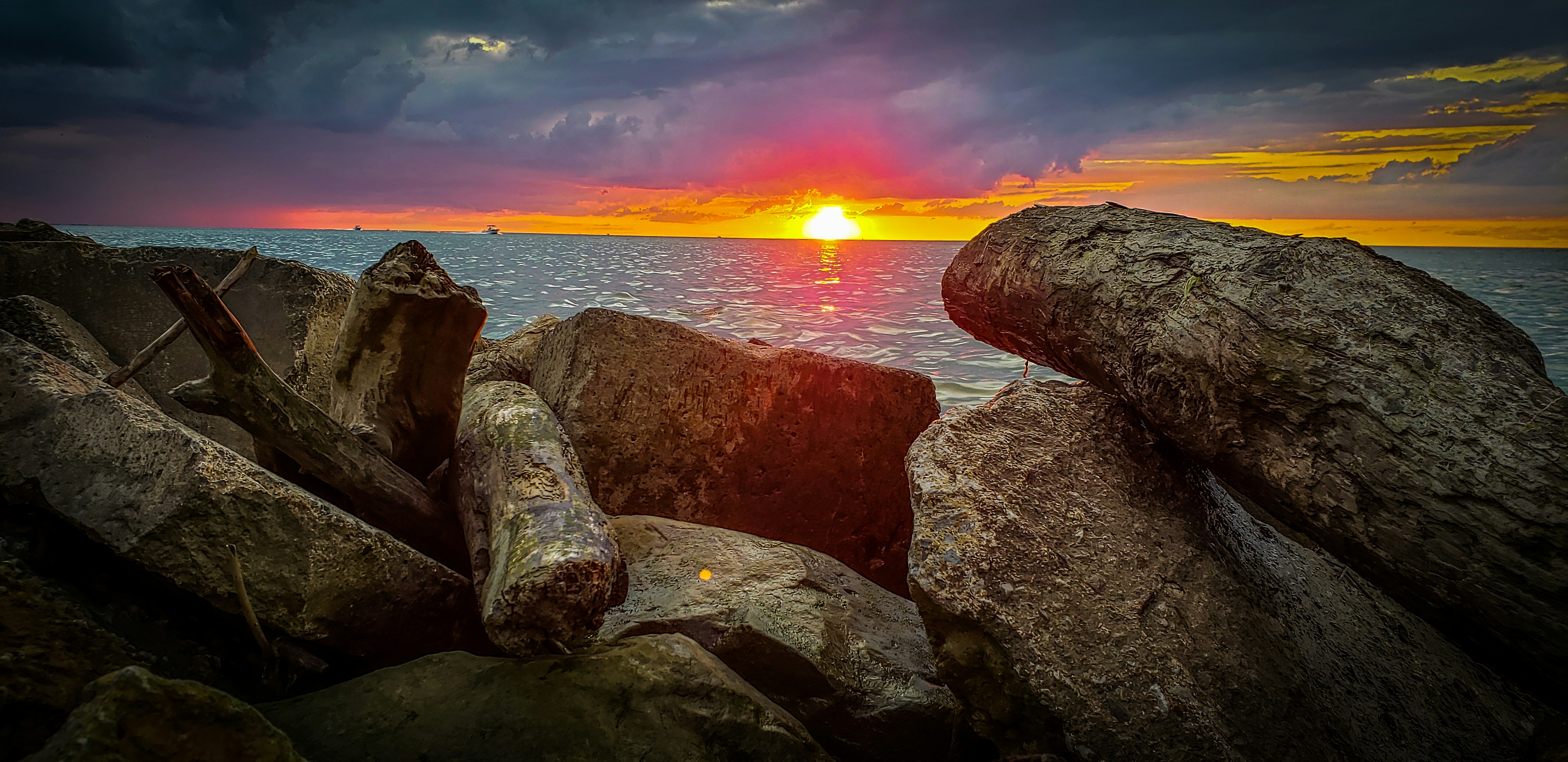 brown and gray rock formation near body of water during sunset