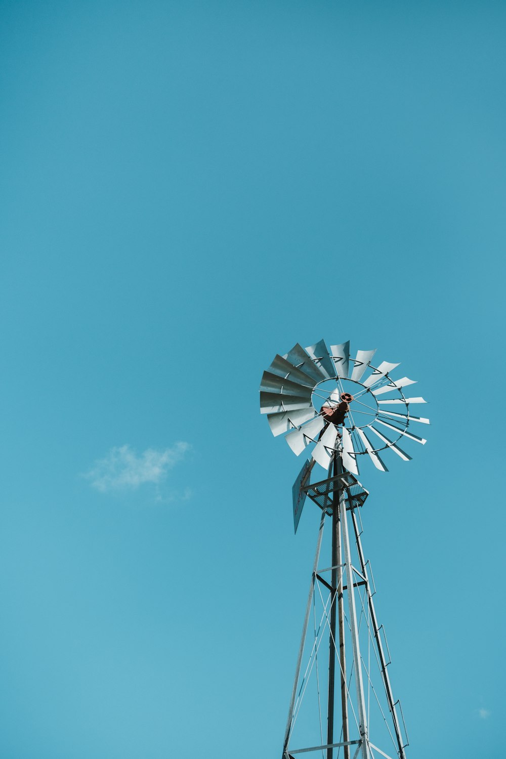 weiße und schwarze Windmühle unter blauem Himmel tagsüber