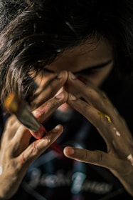 A close-up of an artist's hands working on a canvas.