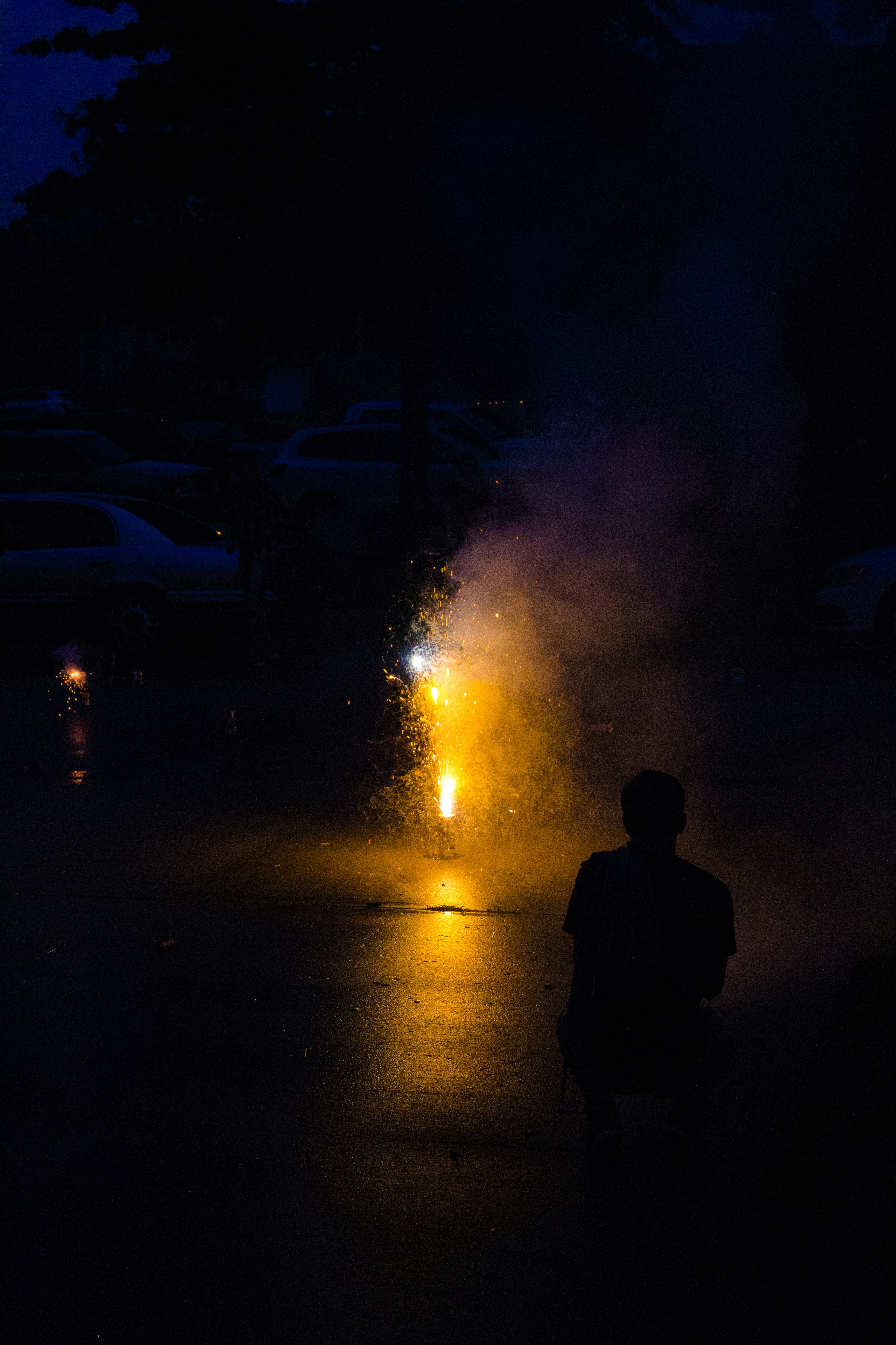 silhouette of man standing near white car during night time