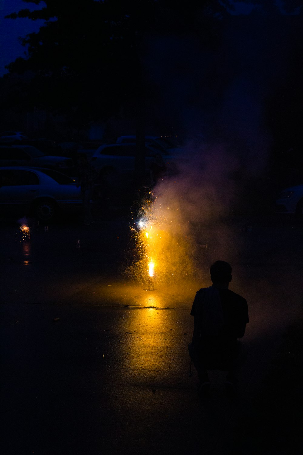 silhouette of man standing near white car during night time