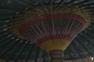 Close-up of a colorful Olefin fabric umbrella providing shade in a sunny garden setting.