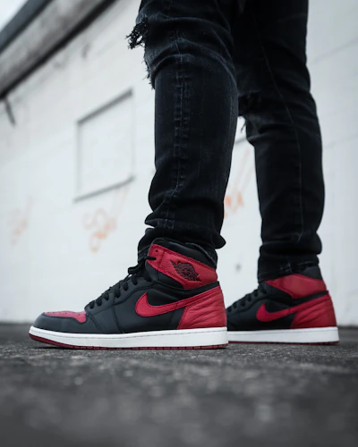 Close-up shot of trendy sneakers paired with ripped jeans on a city sidewalk.