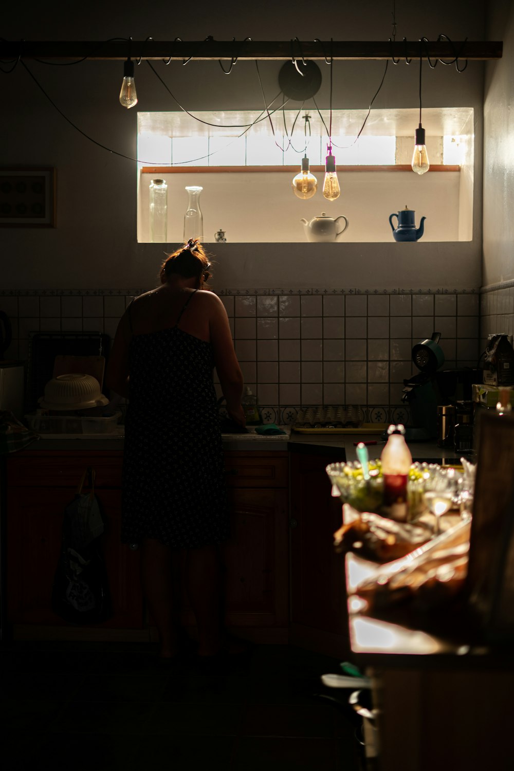 woman in black and white floral sleeveless dress standing in kitchen