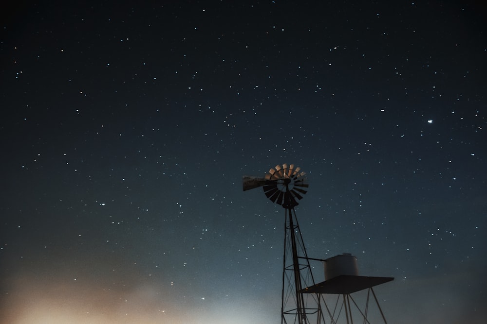 silhouette of windmill under starry night