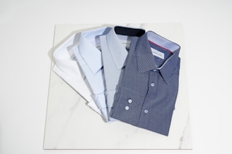 blue button up shirt on white table