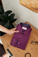 purple button up shirt on brown wooden table