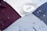 Several neatly arranged dress shirts featuring various patterns and colors, including white, burgundy, dark blue, and light blue. The shirts display button details and fine fabric textures, reflecting a sense of organization and style.