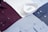 Several neatly arranged dress shirts featuring various patterns and colors, including white, burgundy, dark blue, and light blue. The shirts display button details and fine fabric textures, reflecting a sense of organization and style.