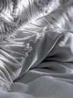 Close-up of a woven throw draped over a chair, highlighting tactile linen fabric