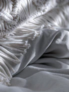 Close-up of a handwoven throw draped over a rustic wooden bench.