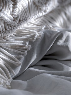 A close-up of a beautifully textured blanket folded neatly on a bed.