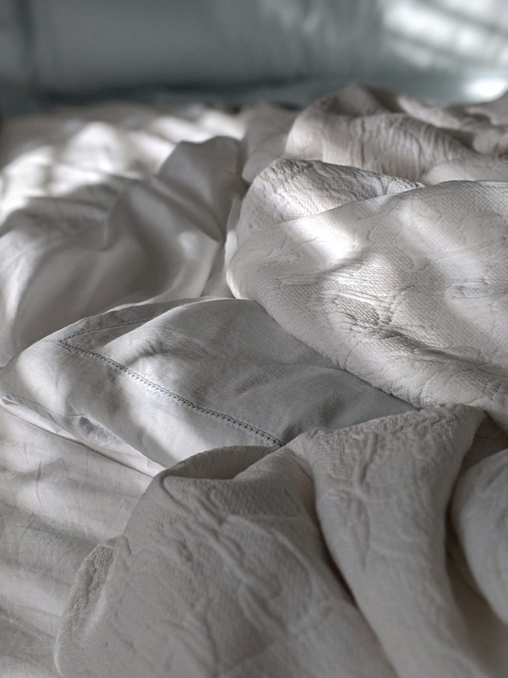 white bed cover with white blanket