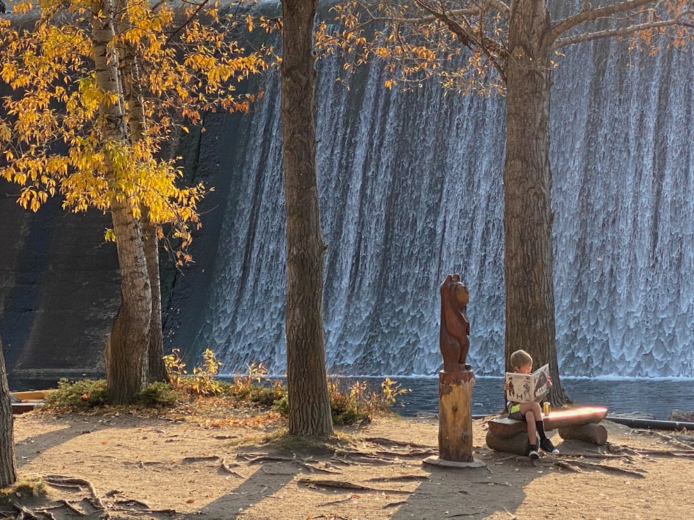 woman in brown dress sitting on bench near body of water during daytime