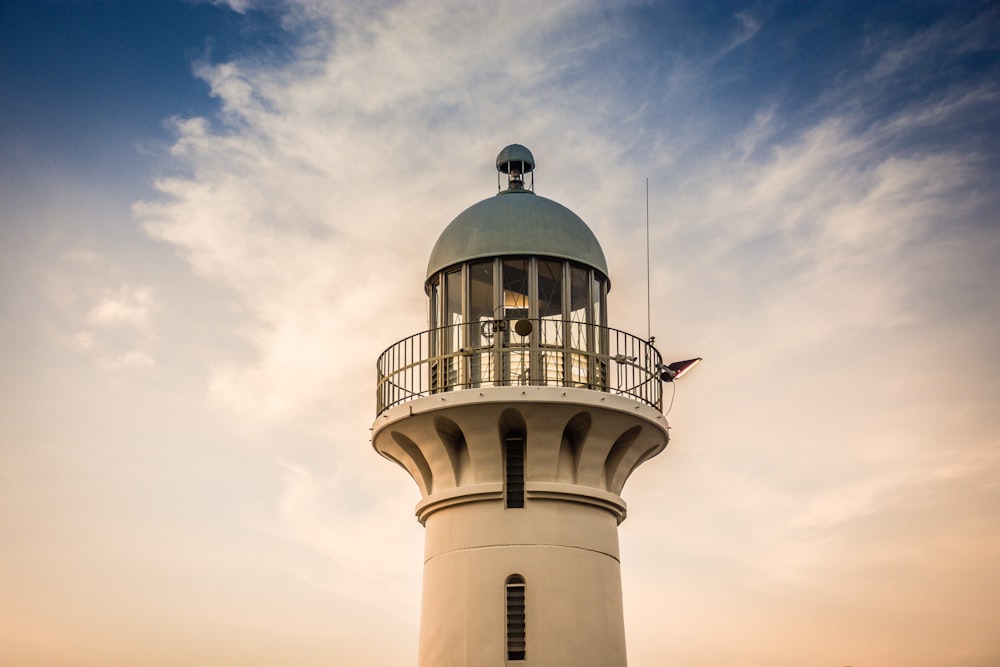 a white lighthouse with a blue sky in the background