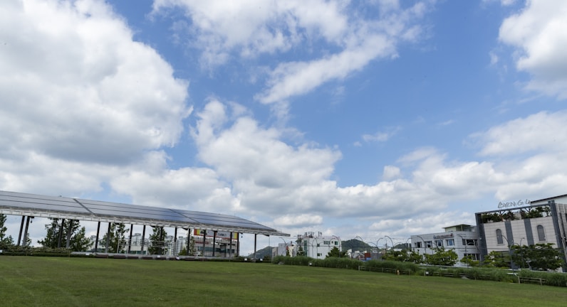 A vibrant green field with weather sensors and solar panels under a clear blue sky