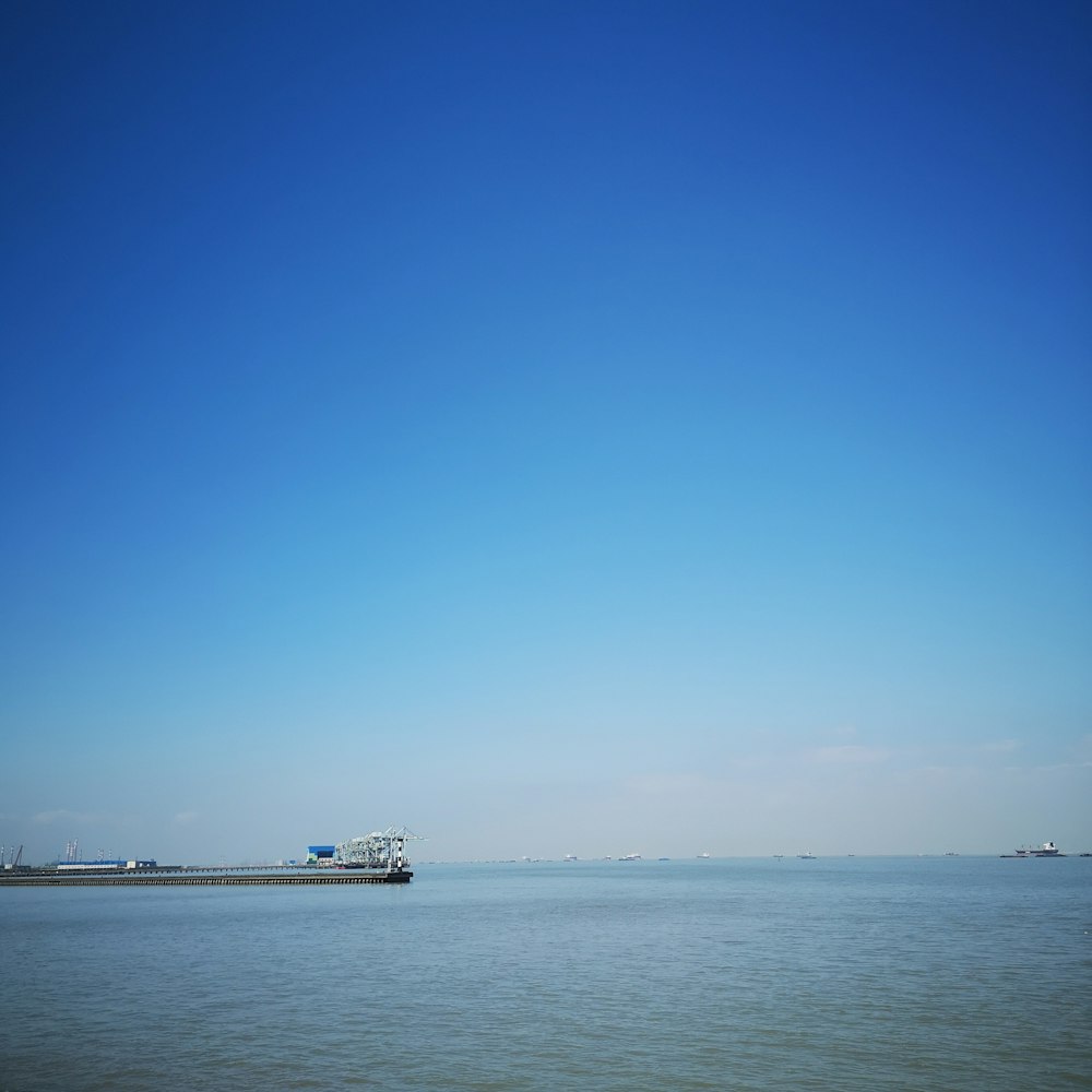 a large body of water sitting under a blue sky