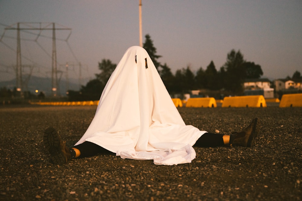 person in white robe standing on ground during daytime