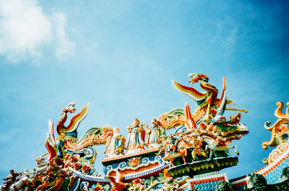 green and brown dragon statue under blue sky during daytime