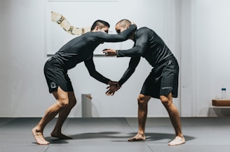 man in black t-shirt and black shorts doing push up