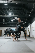 woman in black and white long sleeve shirt and black shorts running on gray concrete floor