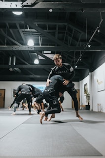 woman in black and white long sleeve shirt and black shorts running on gray concrete floor