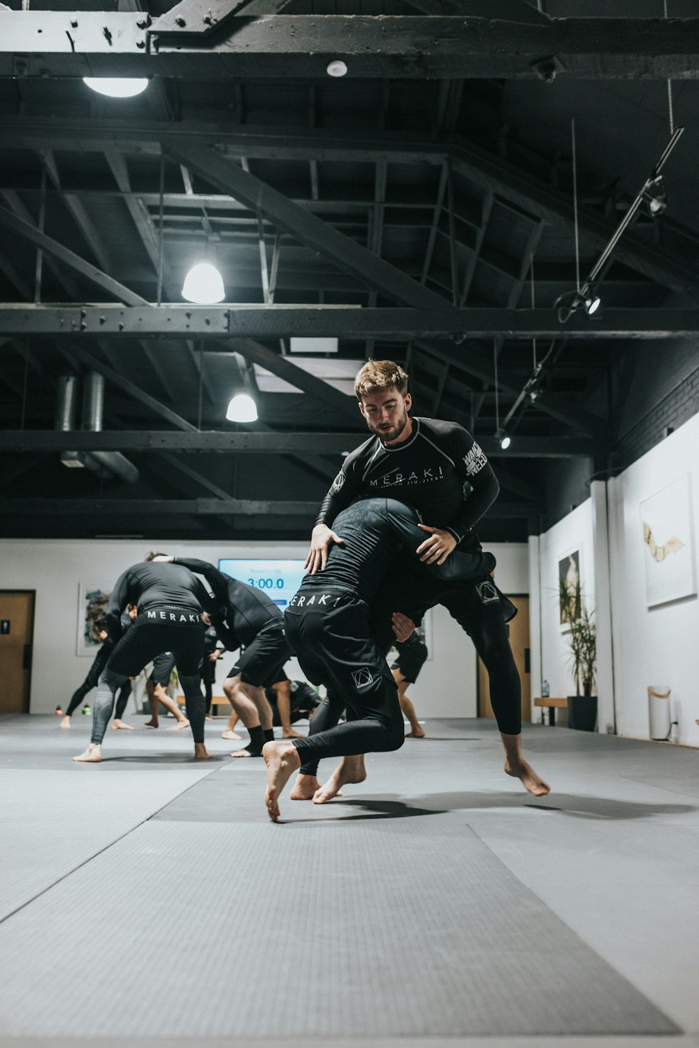 woman in black and white long sleeve shirt and black shorts running on gray concrete floor