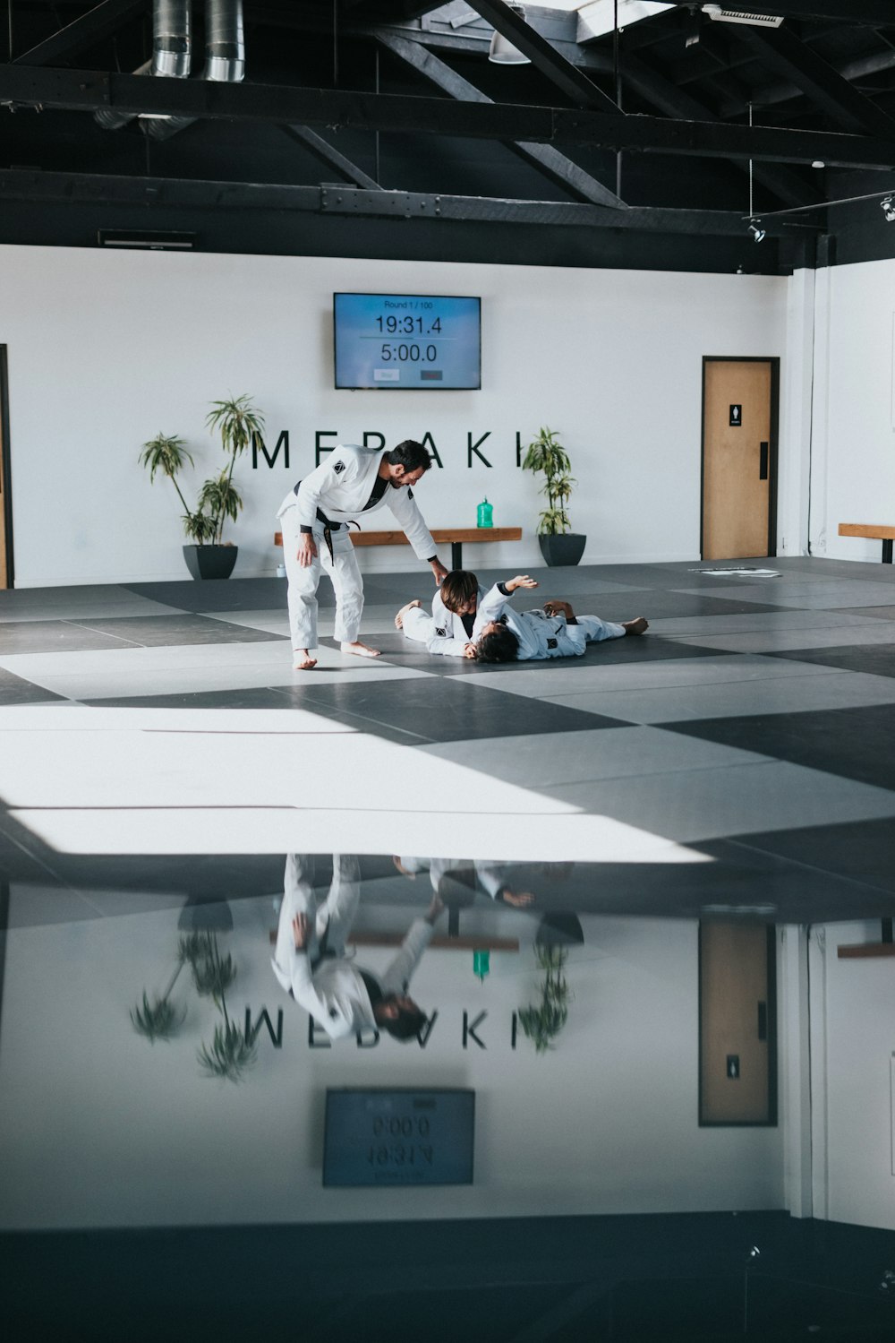 man in white shirt and black pants sitting on white floor