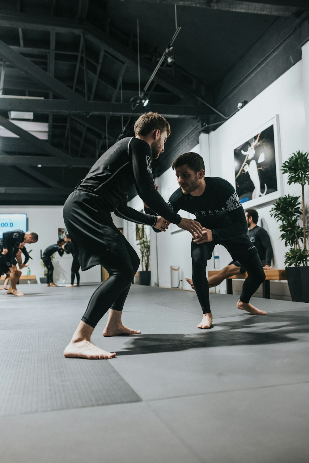 man in black long sleeve shirt and black pants doing push up