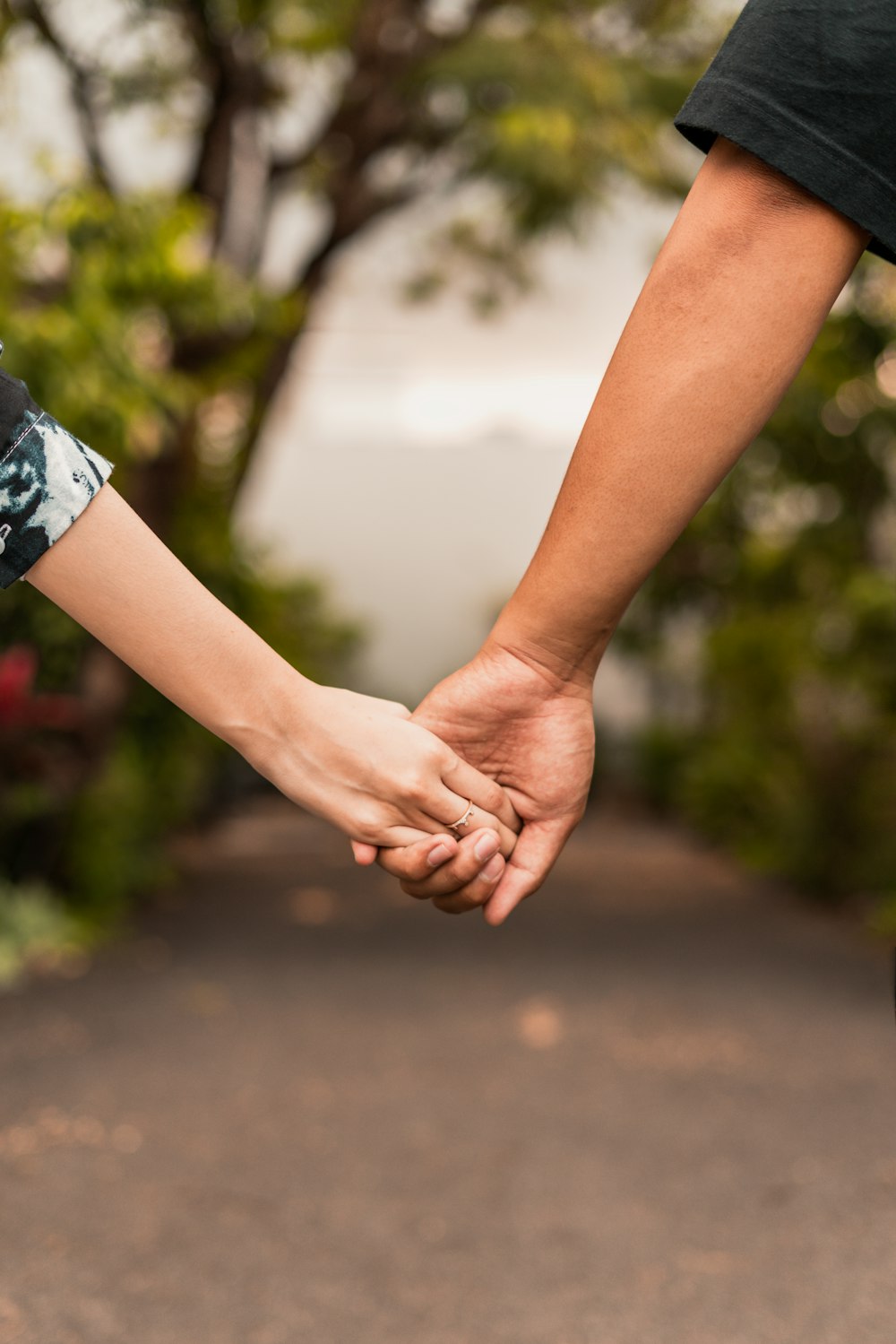 person in blue and white floral shirt holding hands