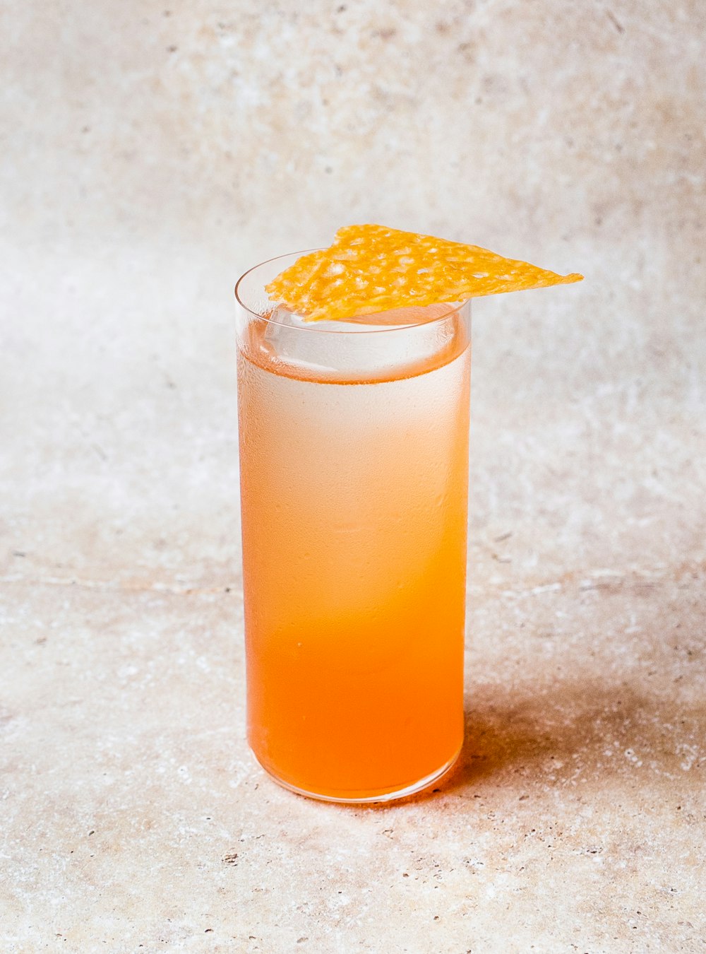 オレンジ色の液体が入った透明なグラス