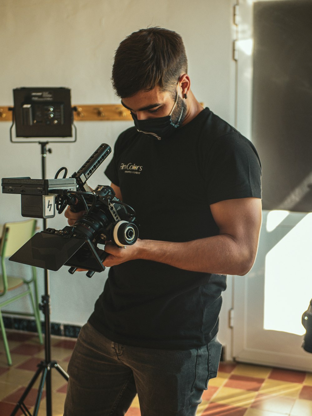 man in black crew neck t-shirt holding black camera