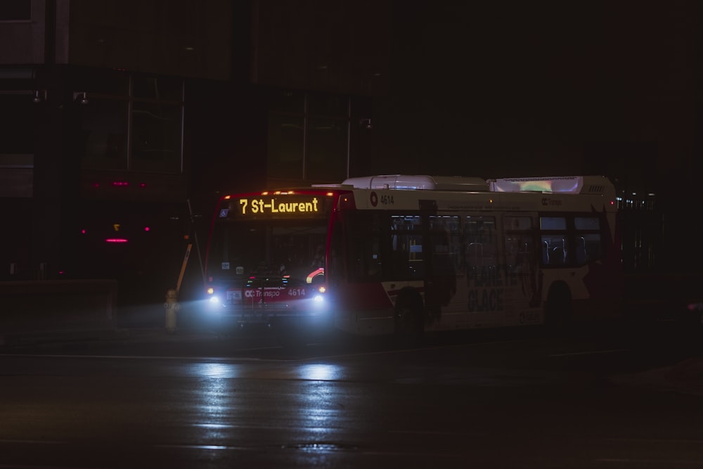 red and white bus on road during night time