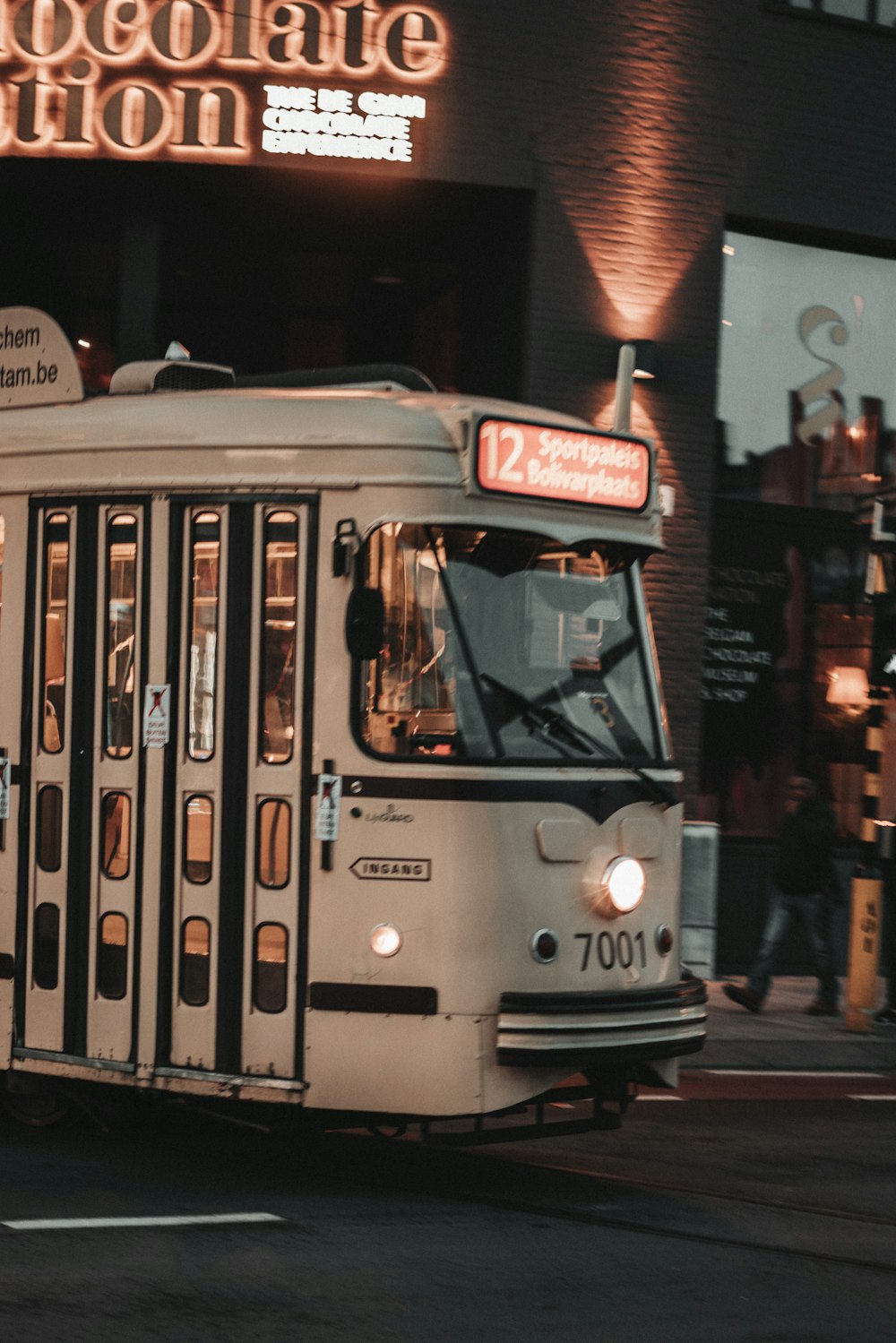 white and red tram on the street during night time