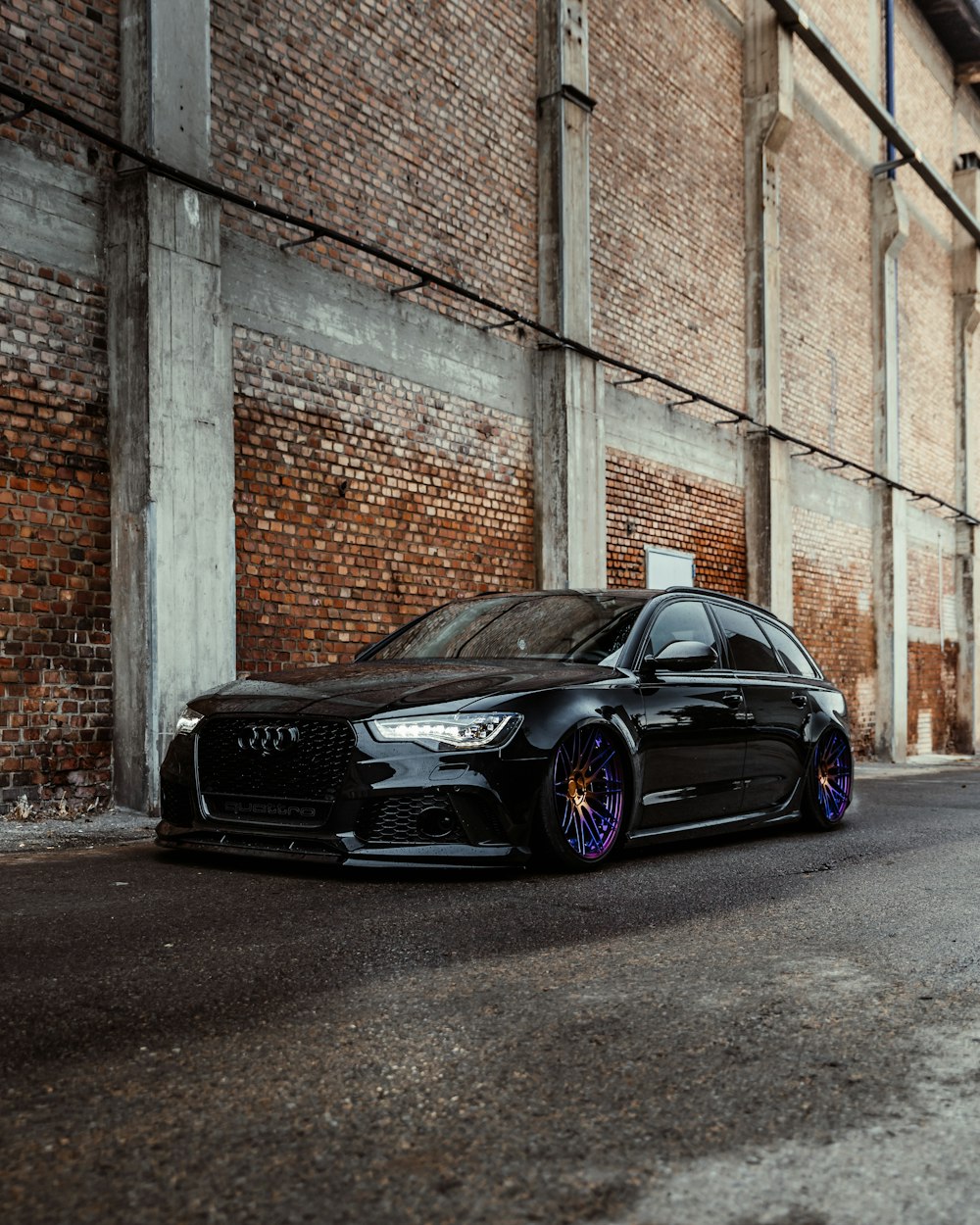 black bmw m 3 coupe parked beside brown brick wall