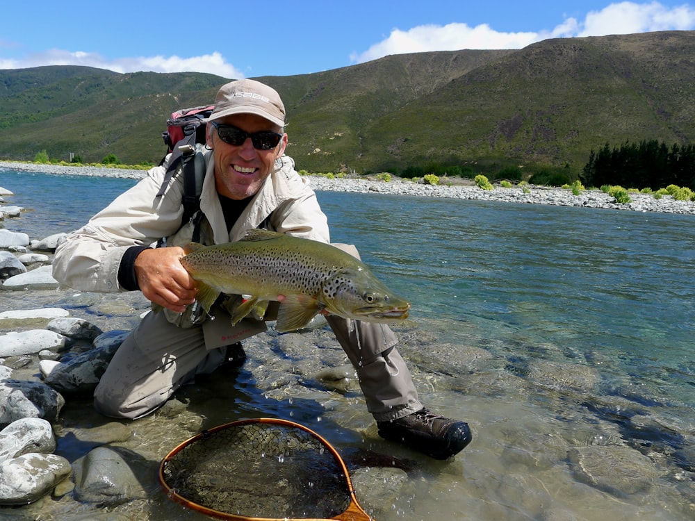 man in black jacket holding fish