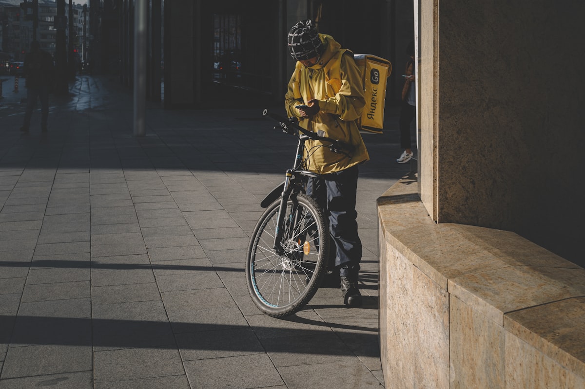 Food delivery courier on a bicycle riding through a city street