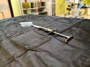 A set of injectable vials arranged on a dark reflective surface with blue ambient light