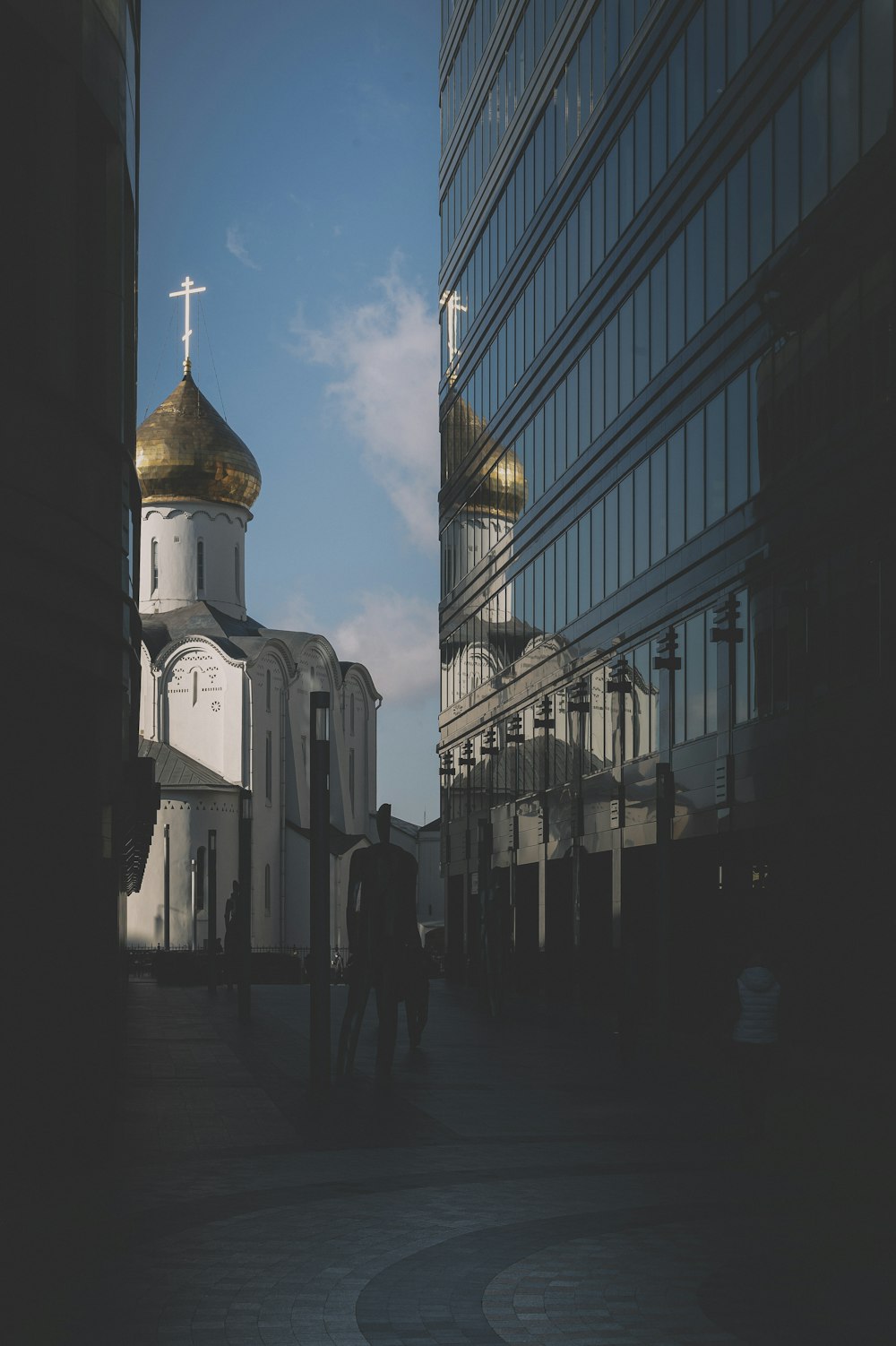 people walking on sidewalk near white and brown cathedral during night time