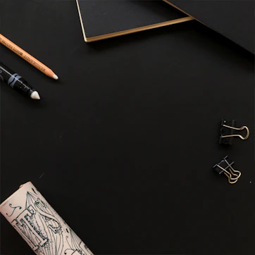 A minimalist workspace with deep navy and slate grey accents, featuring a laptop and elegant stationery.