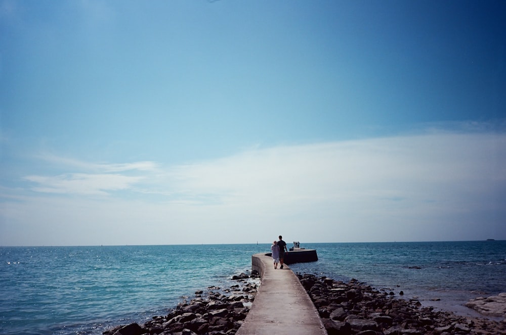 people walking on gray concrete dock during daytime