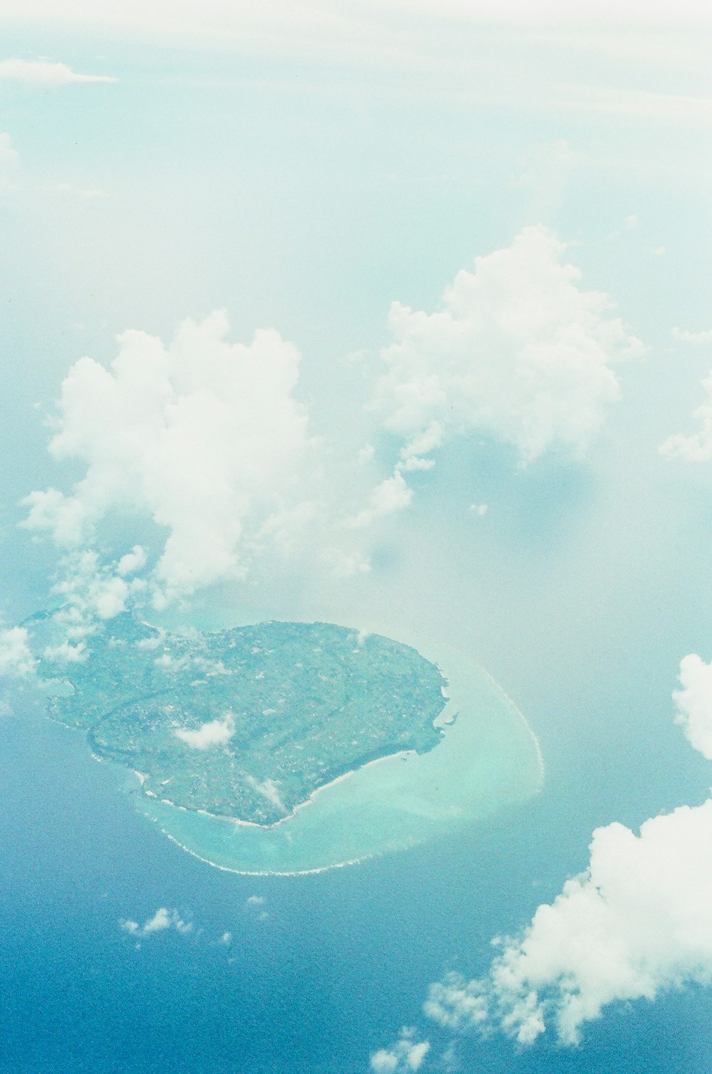aerial view of island surrounded by sea of clouds