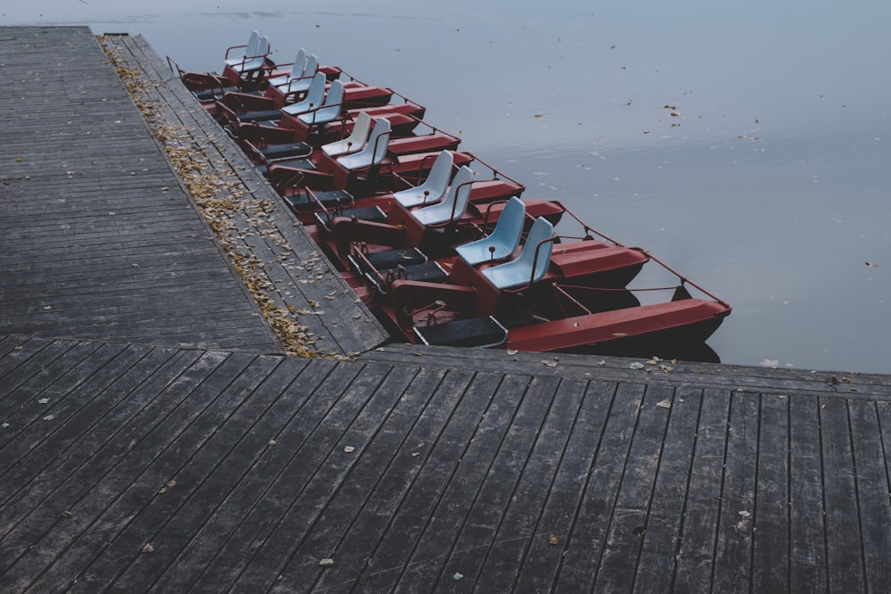 bateau en bois rouge et noir sur le quai de mer pendant la journée