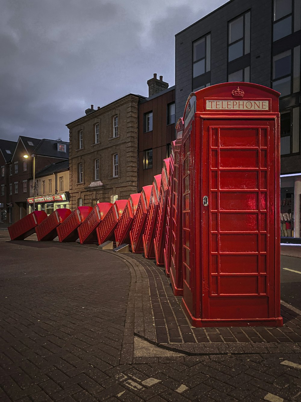 red telephone booth on gray concrete road