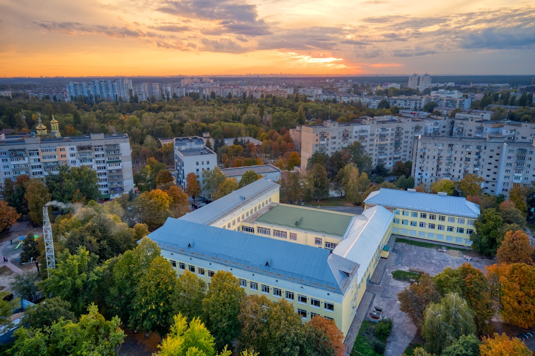 white concrete building surrounded by green trees during daytime