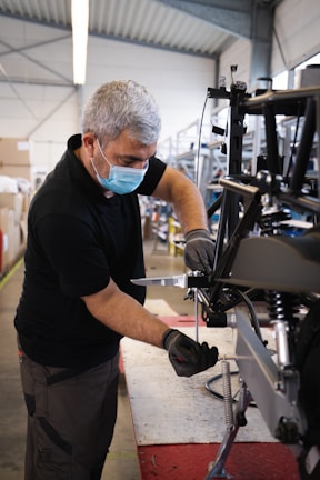 Technician carefully repairing a hospital-grade ventilator in a bright workshop.