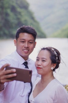man in white suit holding woman in white dress