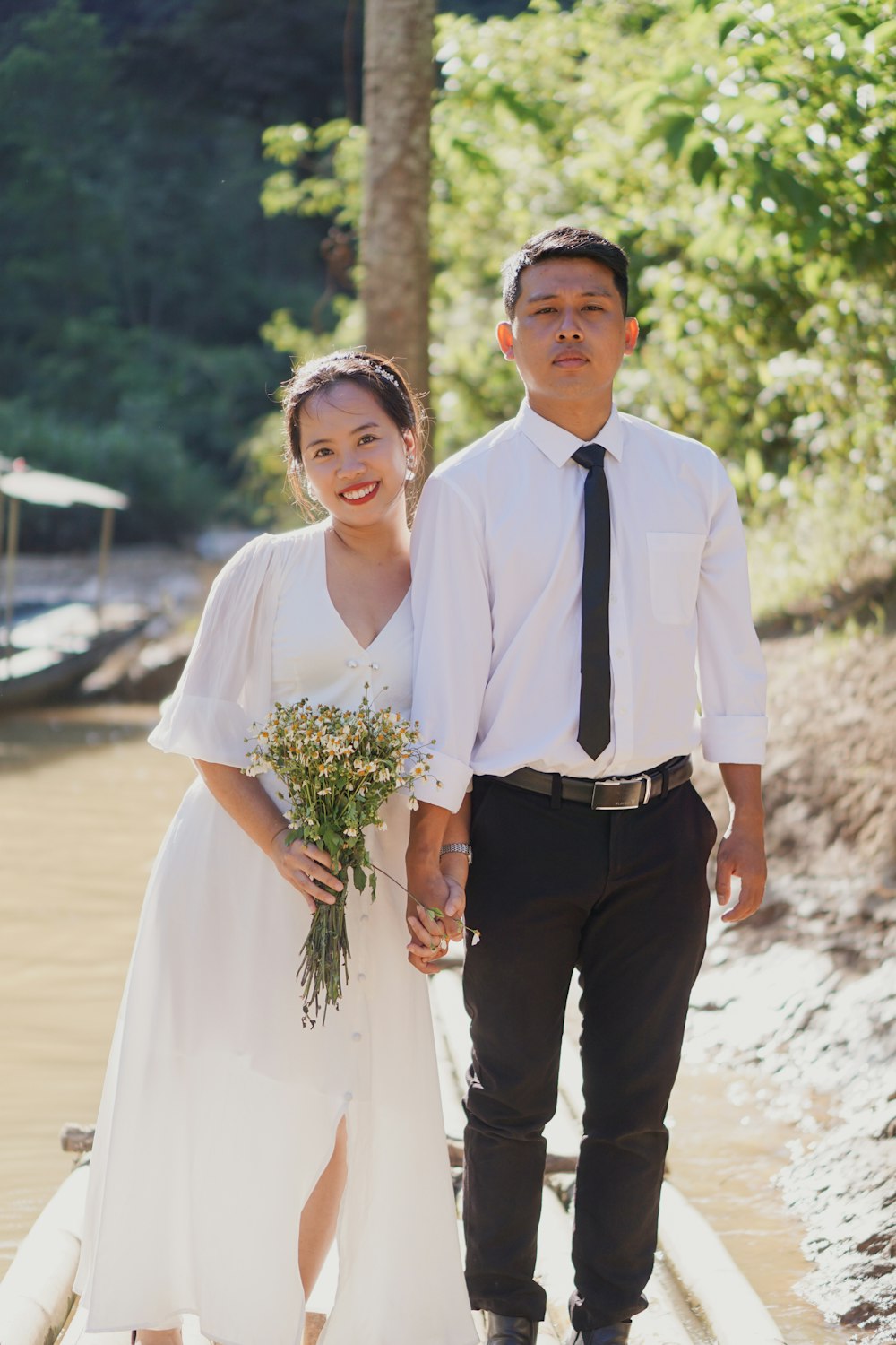 man in white dress shirt and black pants standing beside woman in white dress shirt