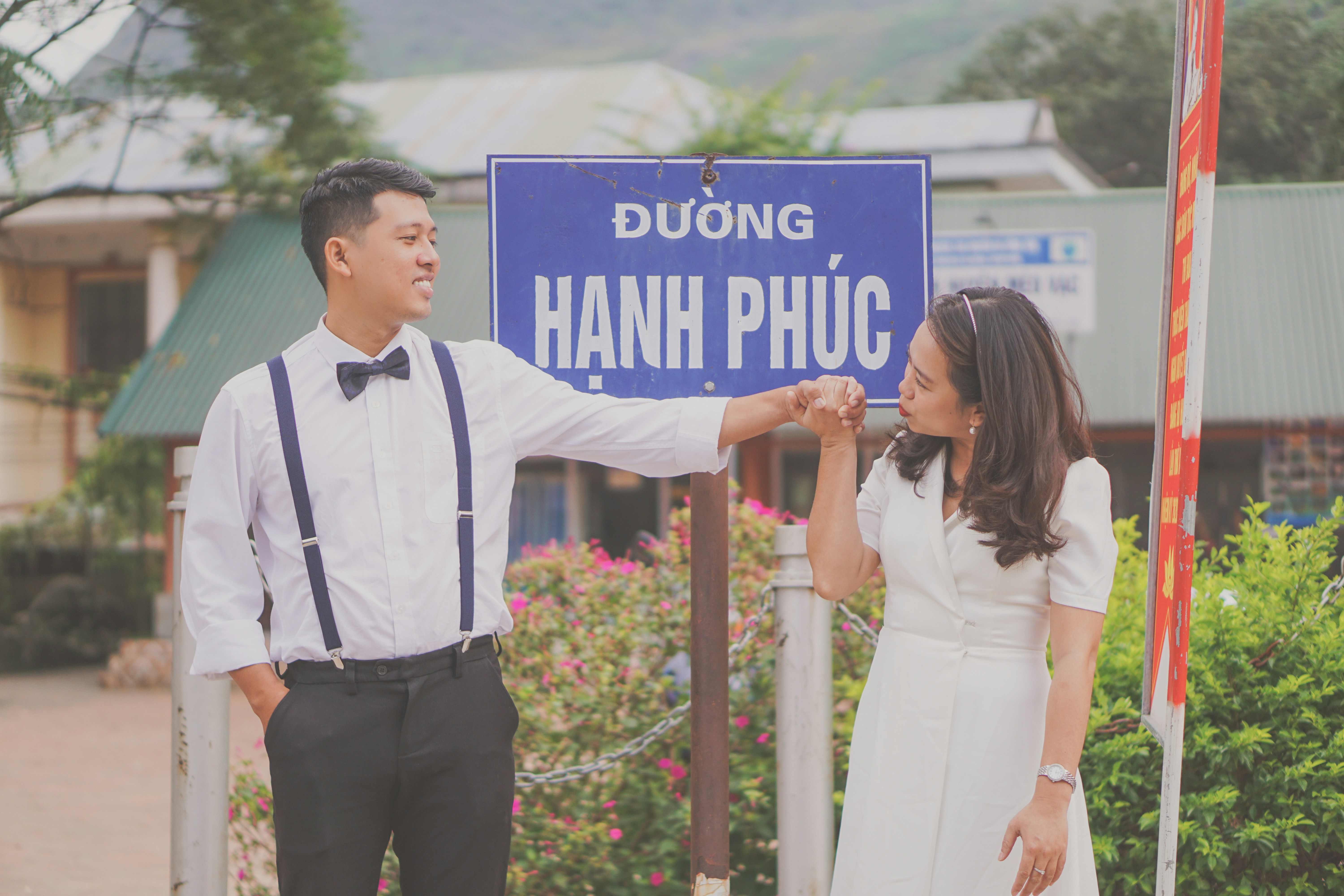 man in black vest and white dress shirt holding blue and white signage