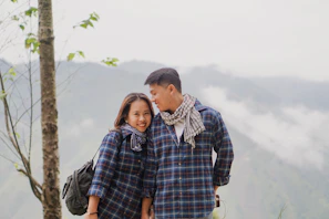 man hugging woman happily in an outdoor setting.